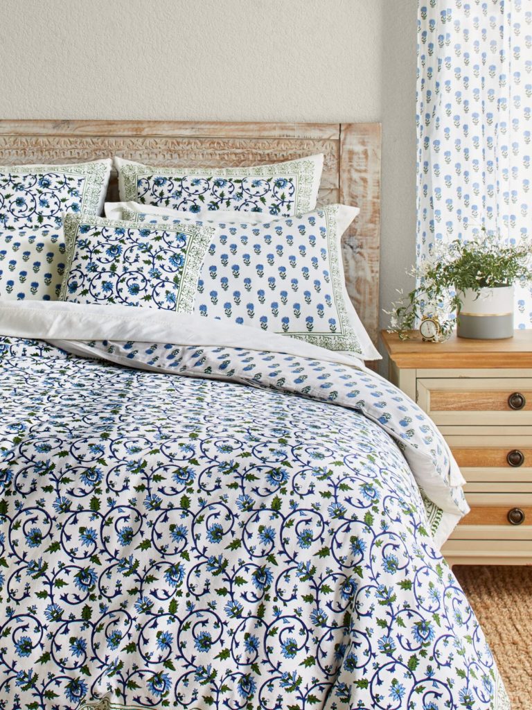 white, blue and green bedding with vines and flowers