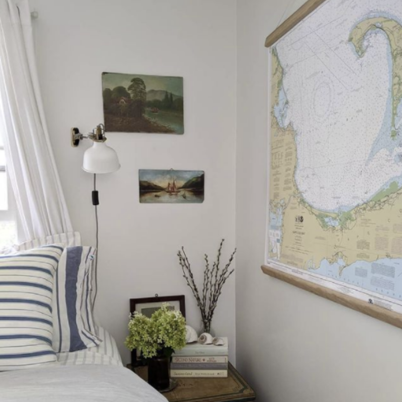 white walls, striped pillows, map and nautical art in a coastal bedroom