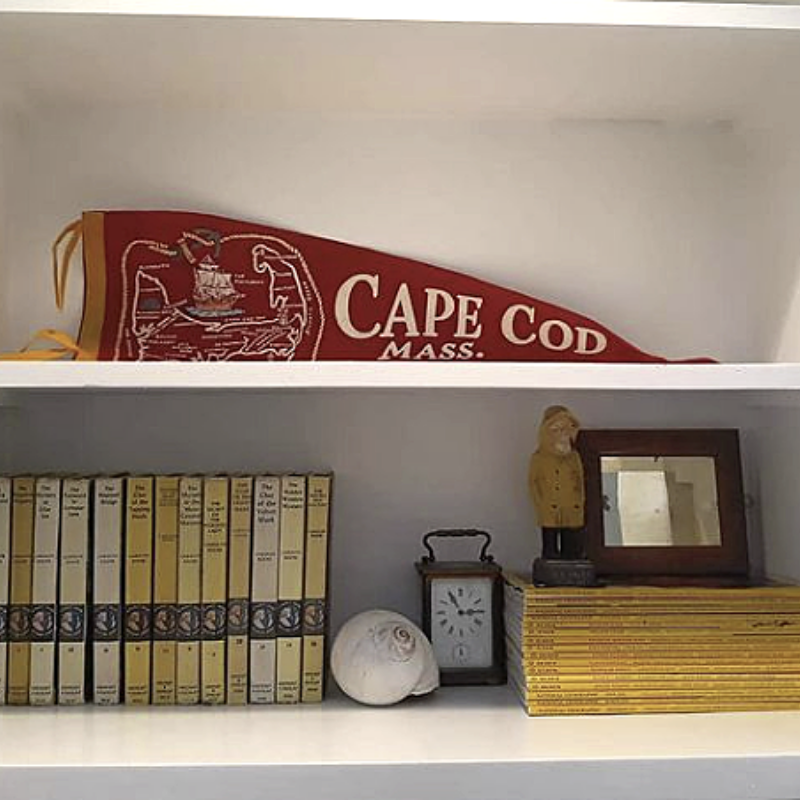 Bookcase styled with shell, Cape Cod pennant, and books