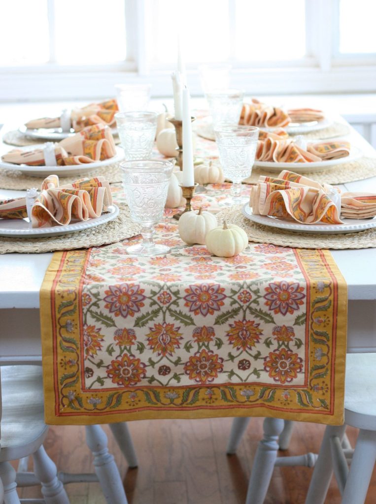 orange table runner and cloth napkins, white pumpkins