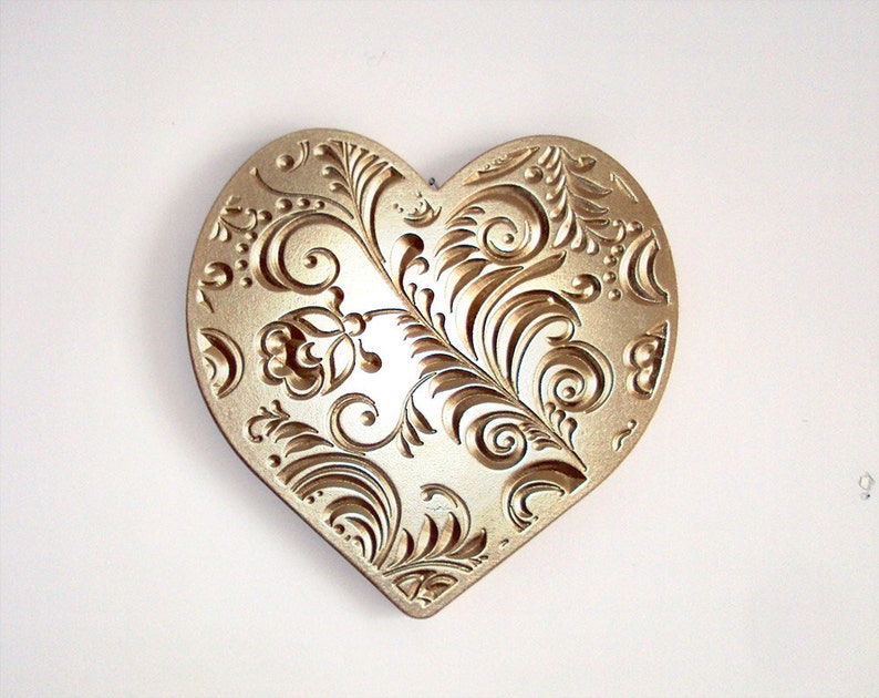 gold heart wedding decoration that resembles a carved wooden block from block printing