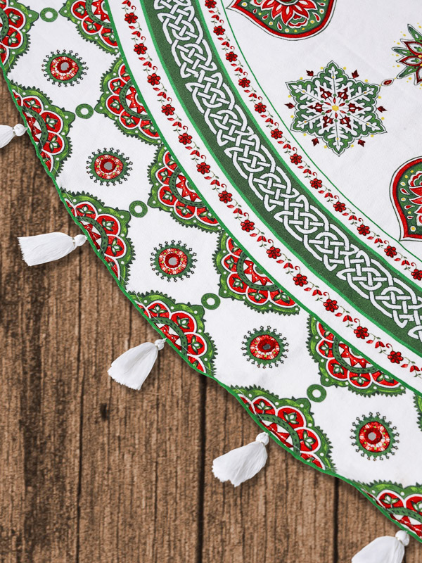 Detail shot of white Christmas tree skirt with Ajrak print and Celtic knot border imagery, tassel edges, and mirror-work