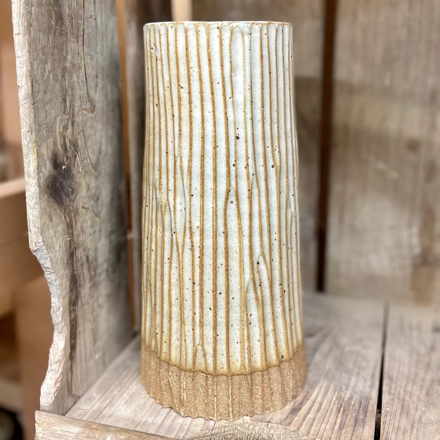 Photograph of a ceramic cylinder vase with grooved texture