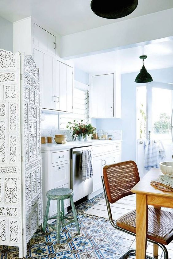 Modern bohemian style dining room using a white palette with earthy accents like brown, blue, and olive