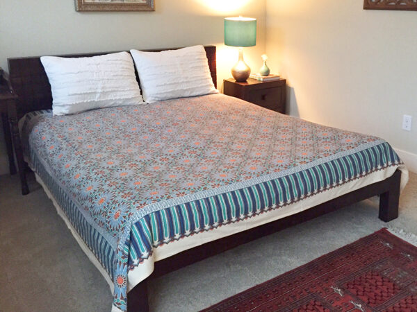 Modern bohemian style bedroom using Moroccan inspired bedding and a traditional rug