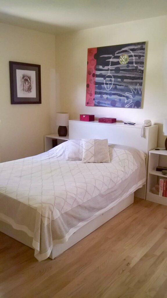 Elegant, modern bohemian style bedroom using white block print bedding and abstract wall art