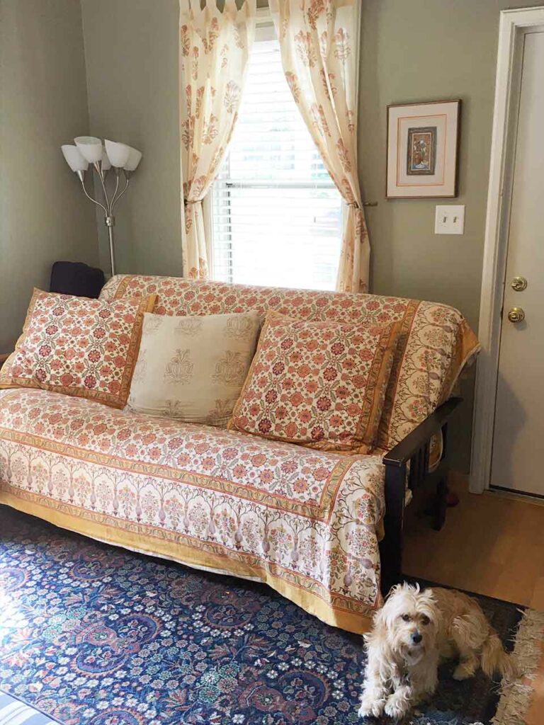 Photograph of neutral living room that uses a pop of color in the furniture and flooring