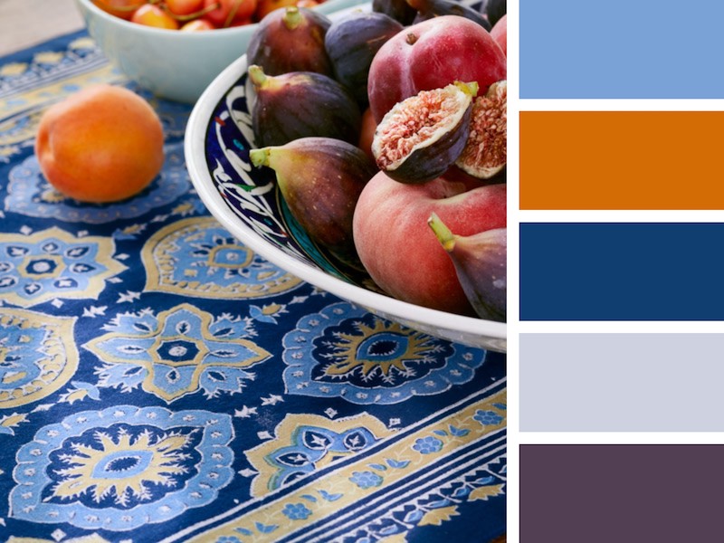 Photograph of a blue table setting with accents of gold and orange to demonstrate when is wedding season for the fall and how to decorate for it