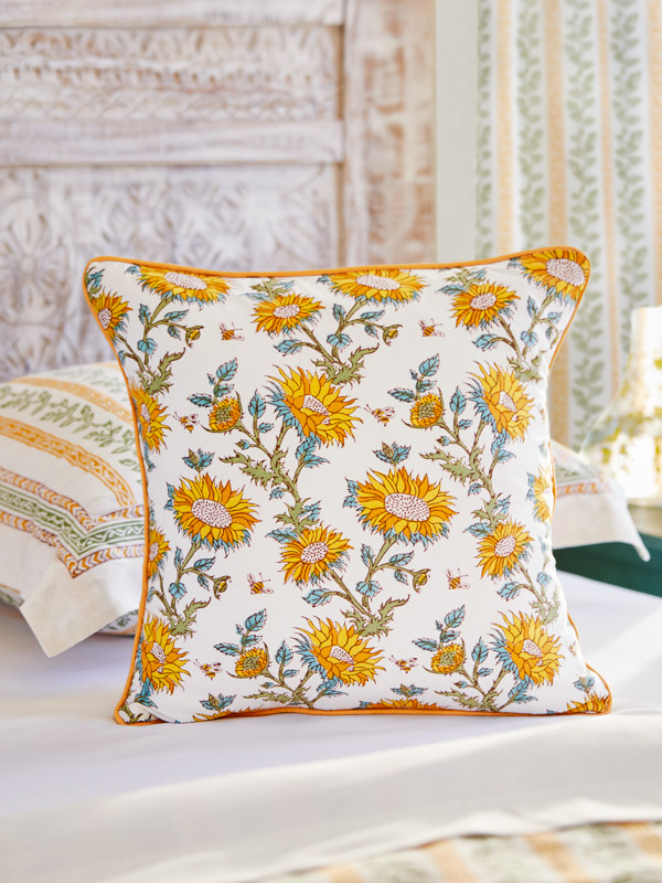 Photograph of a bee and sunflower botanic pattern featuring yellow, orange, green sunflowers on a background of white