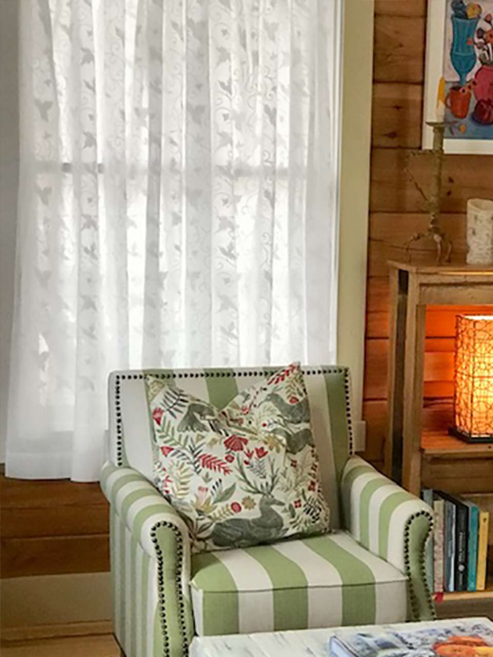 cottage style living room with white sheer curtains and wood paneling